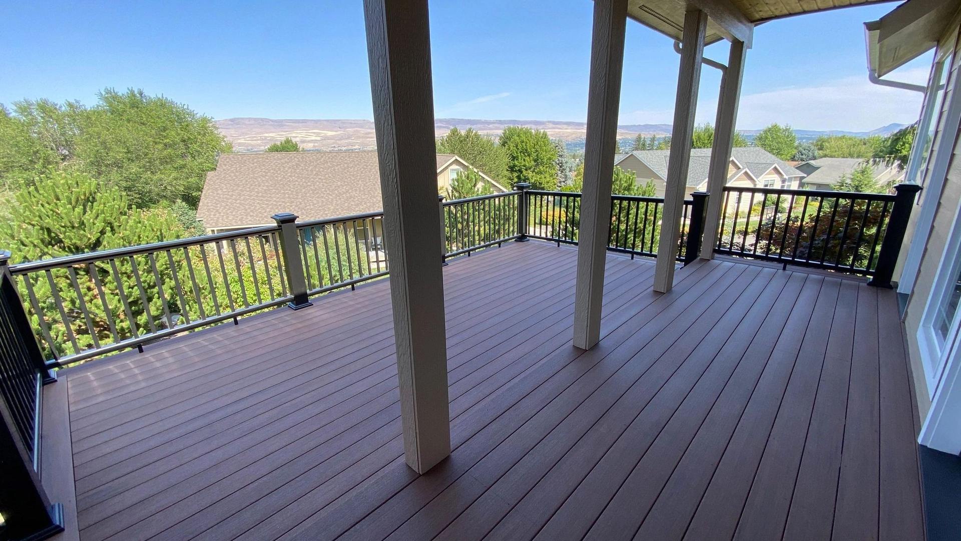 Elevated outdoor deck with covered seating and black railing